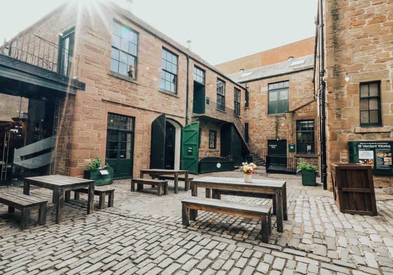 Verdant Works courtyard with picnic benches and green doors